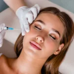 Young woman gets beauty facial injections in salon